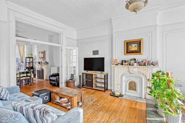 bedroom featuring hardwood / wood-style floors, a textured ceiling, radiator, ornamental molding, and ceiling fan