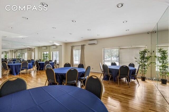 dining area with recessed lighting, light wood-type flooring, and a wall mounted AC