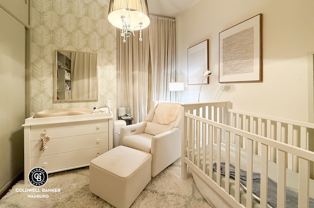 bedroom featuring a chandelier and a crib