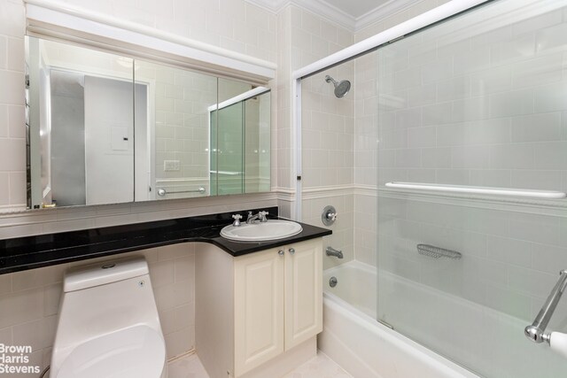 full bathroom with vanity, bath / shower combo with glass door, ornamental molding, and toilet