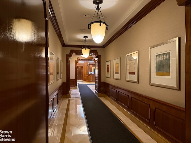 hallway with crown molding and light tile patterned floors