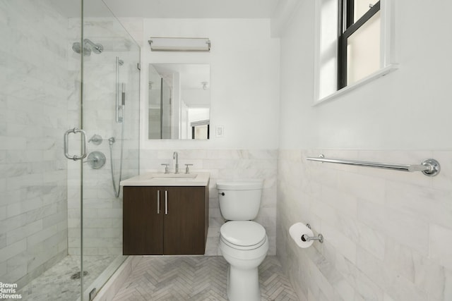 bathroom featuring an enclosed shower, vanity, toilet, and tile walls