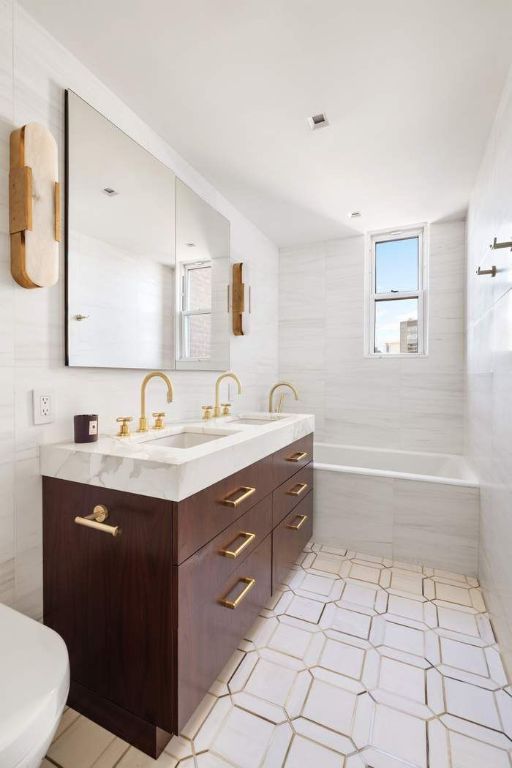 full bathroom with tiled shower / bath, vanity, toilet, and tile walls