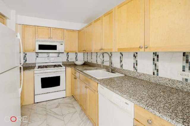 kitchen featuring tasteful backsplash, white appliances, light brown cabinetry, light stone countertops, and sink