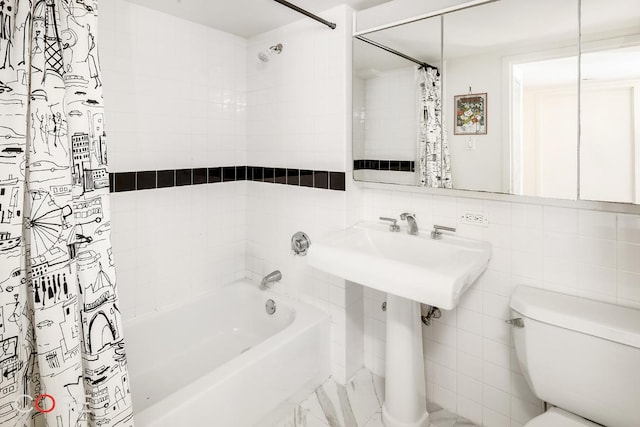 bathroom featuring tile walls, toilet, and shower / bathtub combination with curtain