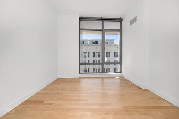 spare room featuring expansive windows and light wood-type flooring