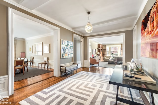 living area featuring crown molding, hardwood / wood-style flooring, and a chandelier