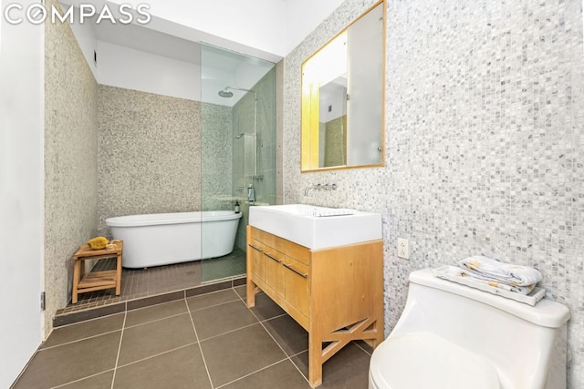 bathroom featuring toilet, tile patterned flooring, walk in shower, and vanity