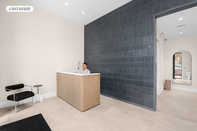 interior space featuring light brown cabinetry and tile walls