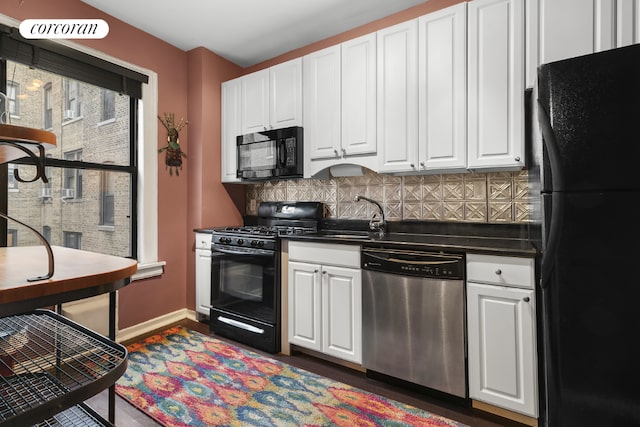 kitchen with black appliances, backsplash, white cabinetry, and sink