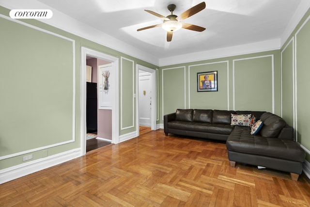 living room with visible vents, a decorative wall, and ceiling fan