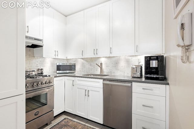 kitchen featuring light tile patterned floors, stainless steel appliances, white cabinets, and sink