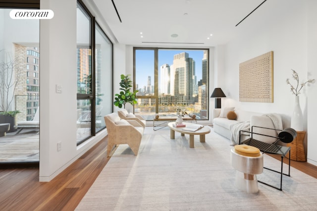 sitting room featuring a healthy amount of sunlight, floor to ceiling windows, and hardwood / wood-style floors