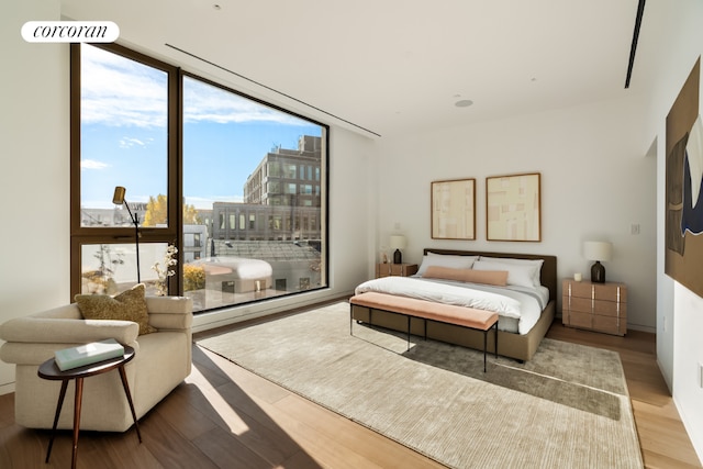 bedroom featuring floor to ceiling windows and hardwood / wood-style flooring