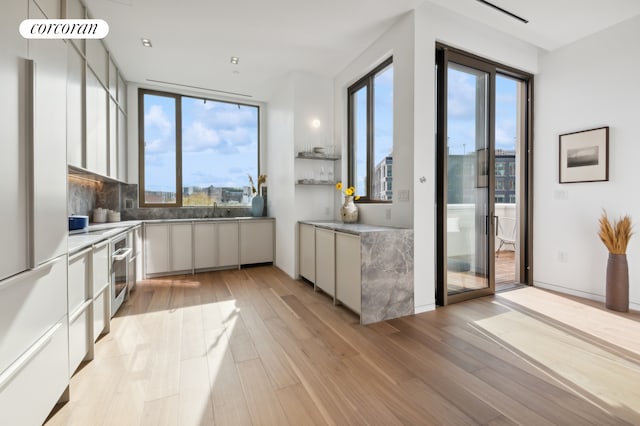 68 Commercial St Ph, Ph, New York City, NY 11222 - kitchen featuring healthy amount of natural light, light wood-type flooring, modern cabinets, and white cabinets