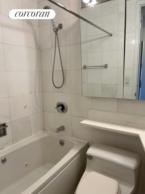 bathroom with toilet and shower / bathing tub combination