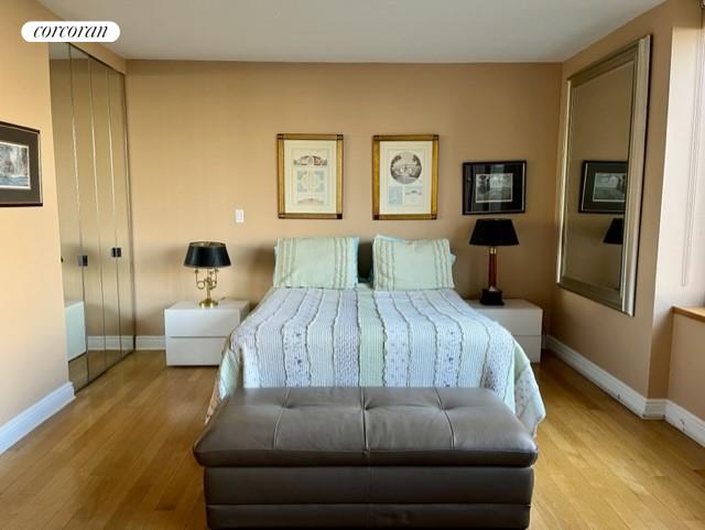 bedroom featuring wood finished floors, visible vents, and baseboards