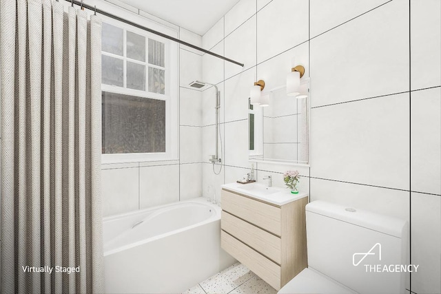 full bathroom featuring toilet, vanity, tile walls, and shower / bathtub combination with curtain