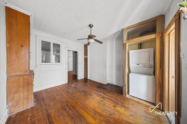 interior space with ceiling fan, stacked washer and clothes dryer, and dark hardwood / wood-style flooring