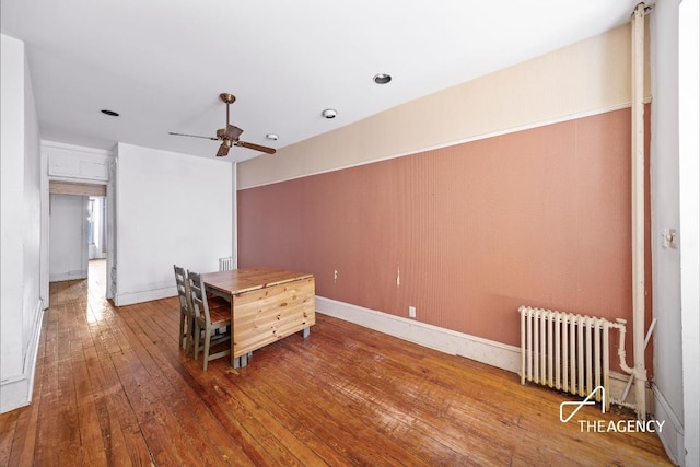 interior space featuring ceiling fan, wood-type flooring, and radiator heating unit