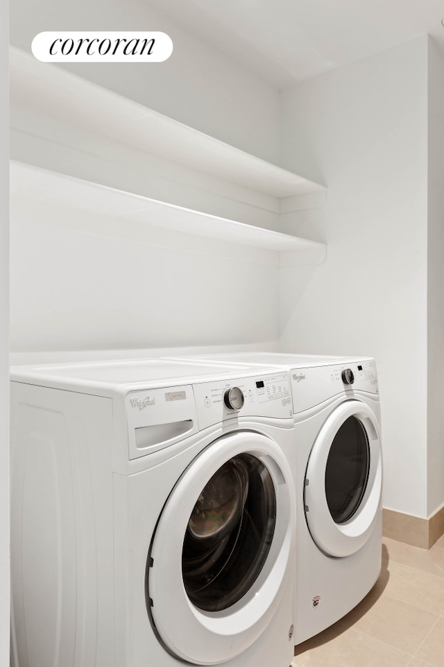 15 Hudson Yards Unit 67F, New York City, NY 10001 - washroom featuring washing machine and clothes dryer, baseboards, and light tile patterned flooring