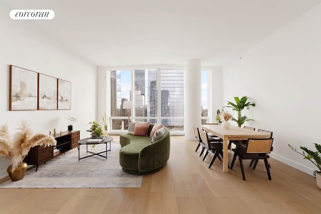 15 Hudson Yards Unit 67F, New York City, NY 10001 - living room with light wood-style floors, baseboards, a view of city, and floor to ceiling windows