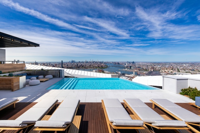 view of swimming pool with a patio area and a water view