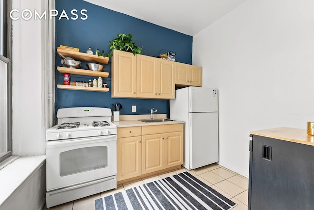 kitchen featuring white appliances, light tile patterned floors, light countertops, light brown cabinetry, and a sink