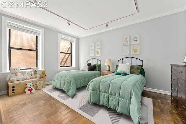 bedroom featuring rail lighting, ornamental molding, and parquet floors