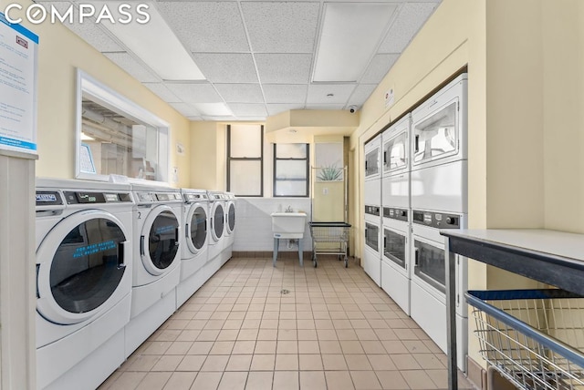 clothes washing area featuring stacked washing maching and dryer, sink, and separate washer and dryer