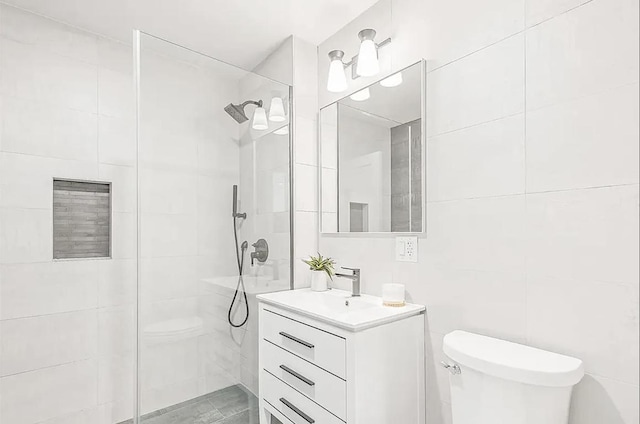 bathroom featuring vanity, tile walls, toilet, and a walk in shower