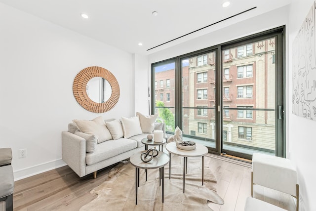 living area featuring recessed lighting, wood finished floors, and baseboards
