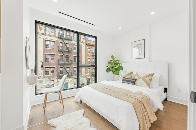 bedroom with recessed lighting, baseboards, and wood finished floors