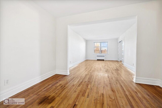 unfurnished living room with radiator and light hardwood / wood-style flooring