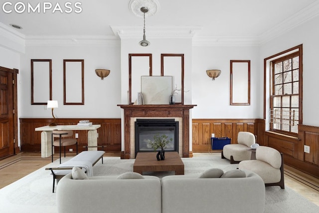 living room featuring light wood-type flooring, wood walls, and ornamental molding