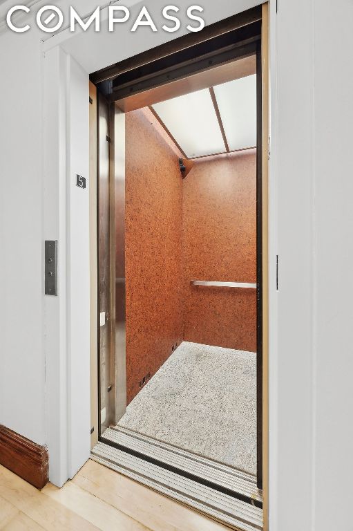 interior details featuring wood-type flooring and elevator