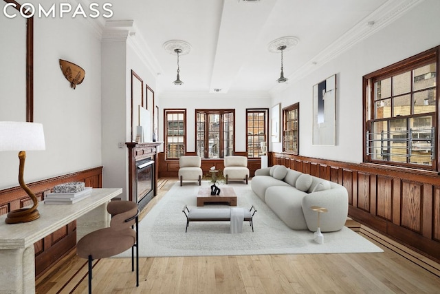 living room featuring ornamental molding and light hardwood / wood-style flooring