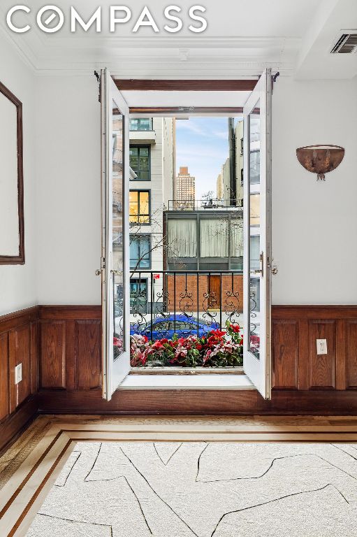 doorway featuring crown molding and hardwood / wood-style flooring