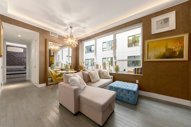 sitting room featuring a notable chandelier, a wealth of natural light, ornamental molding, and hardwood / wood-style floors