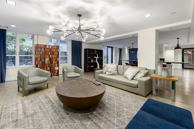 living room with a notable chandelier and light wood-type flooring