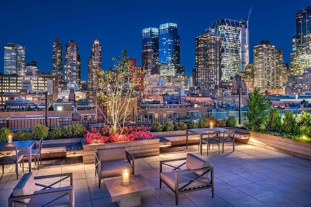 patio at night featuring a view of city lights