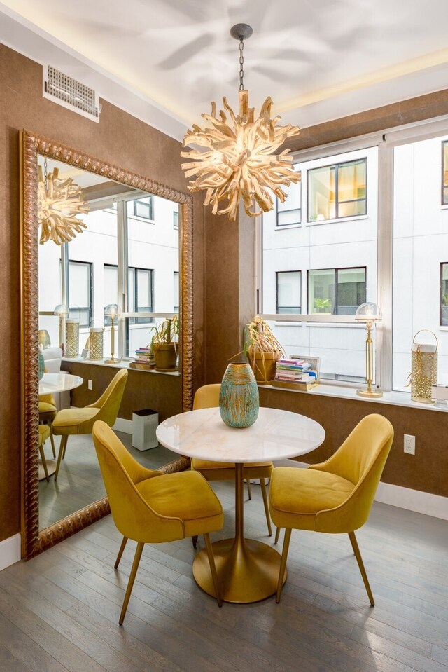 dining area featuring hardwood / wood-style flooring and an inviting chandelier