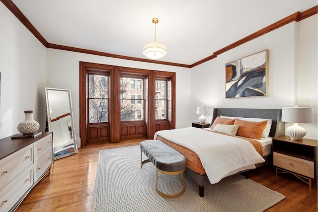 bedroom with crown molding and light hardwood / wood-style flooring