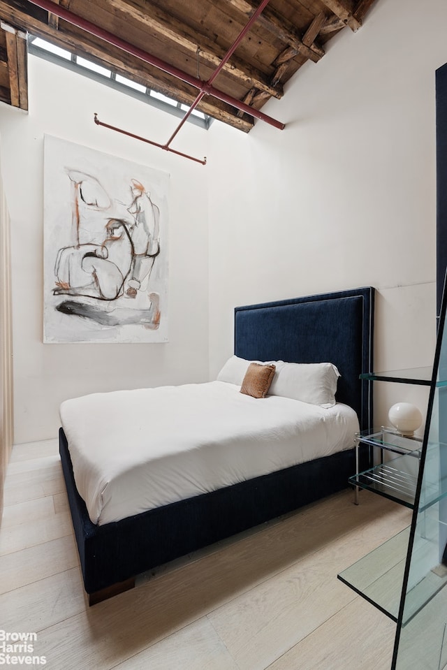 bedroom featuring wooden ceiling, wood finished floors, and beam ceiling