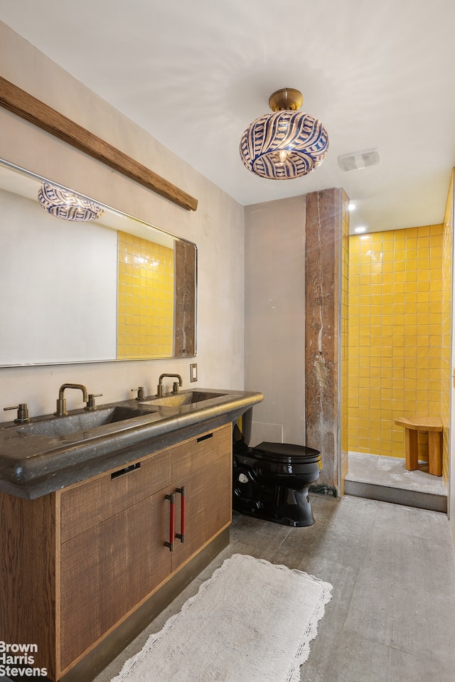 full bath featuring toilet, double vanity, visible vents, and a sink