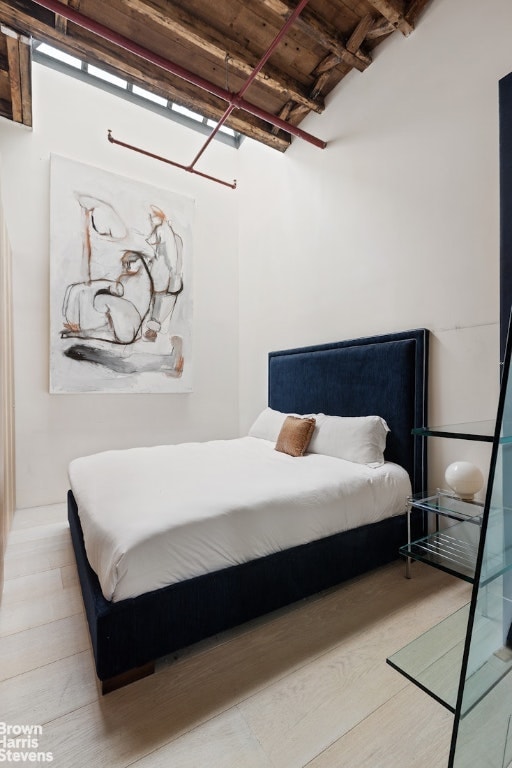 bedroom featuring hardwood / wood-style flooring, wooden ceiling, and beamed ceiling