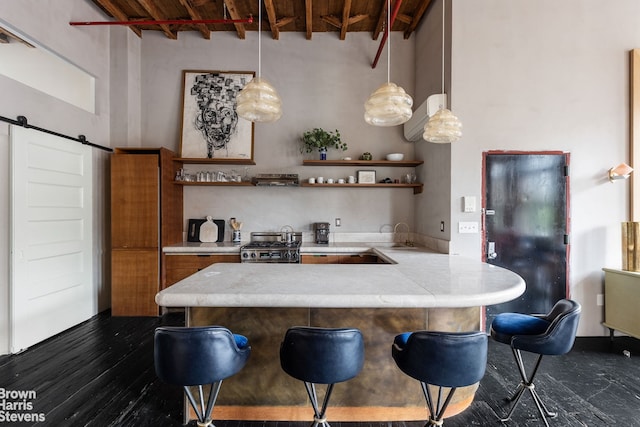 kitchen with open shelves, a barn door, a peninsula, and light countertops