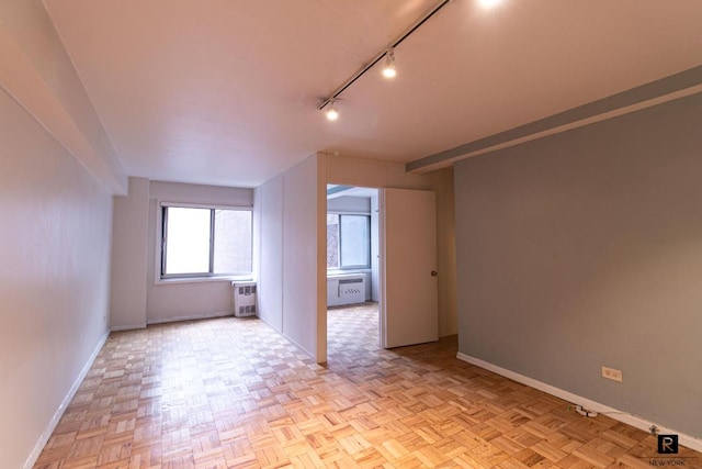 unfurnished room with track lighting and light parquet floors