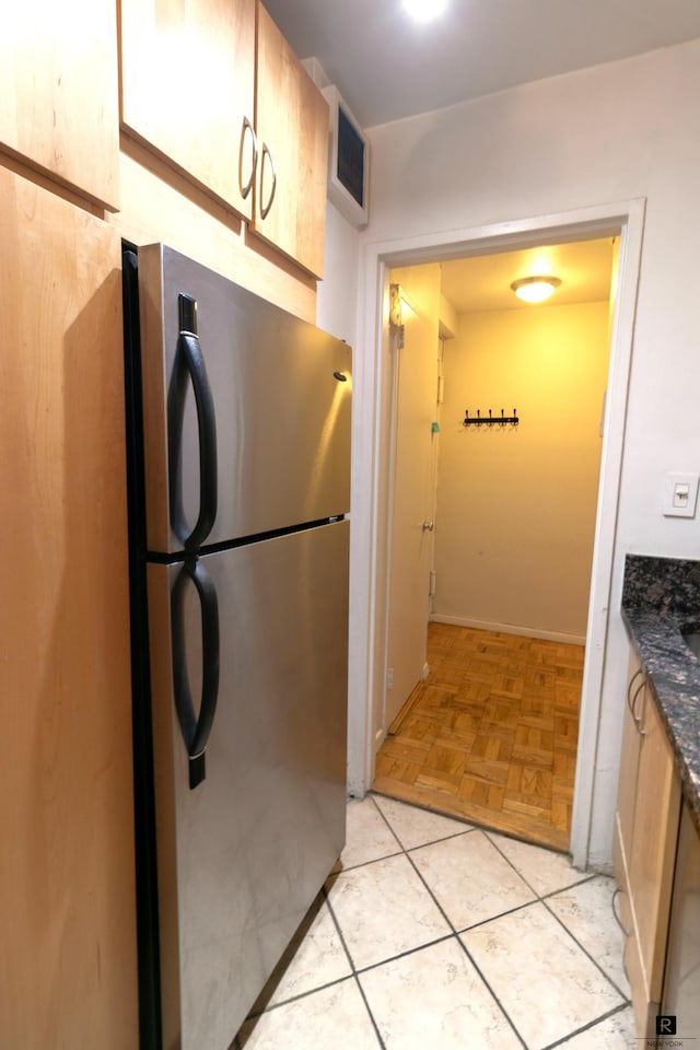 kitchen featuring visible vents, light tile patterned floors, and freestanding refrigerator