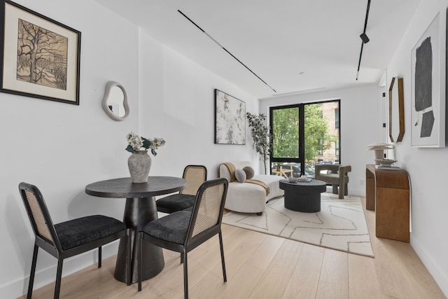 dining space with light wood finished floors and baseboards